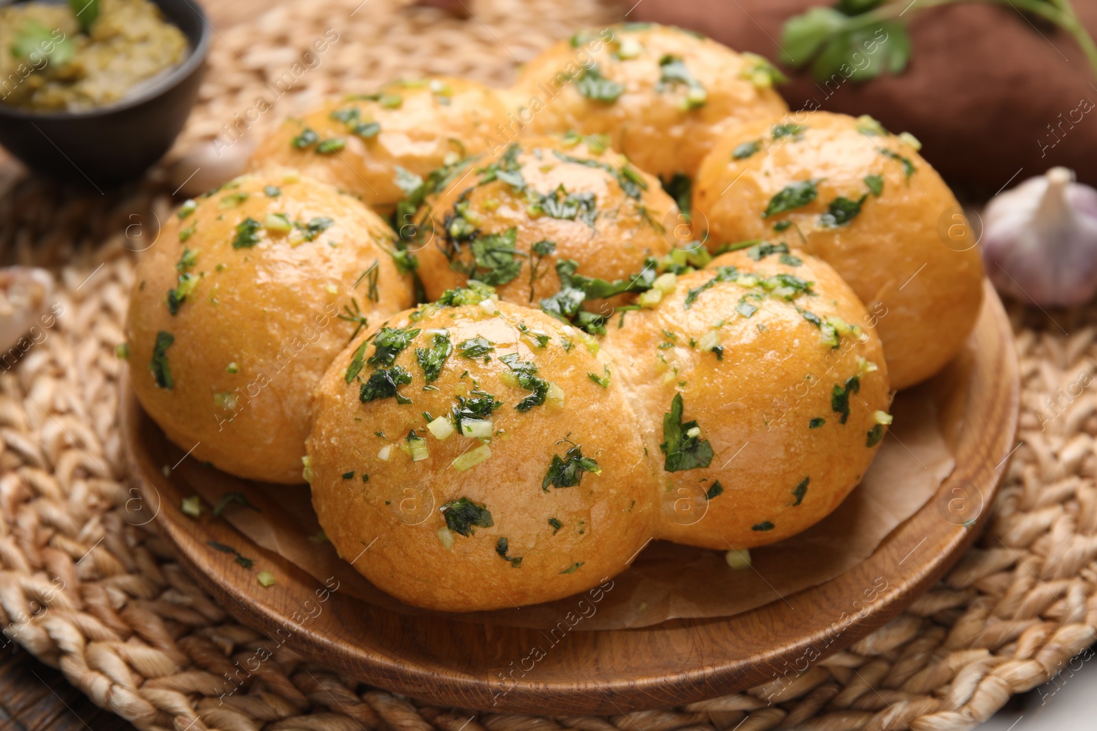 Traditional pampushka buns with garlic and herbs on plate, closeup Photo of Traditional pampushka buns with garlic and herbs on plate, closeup