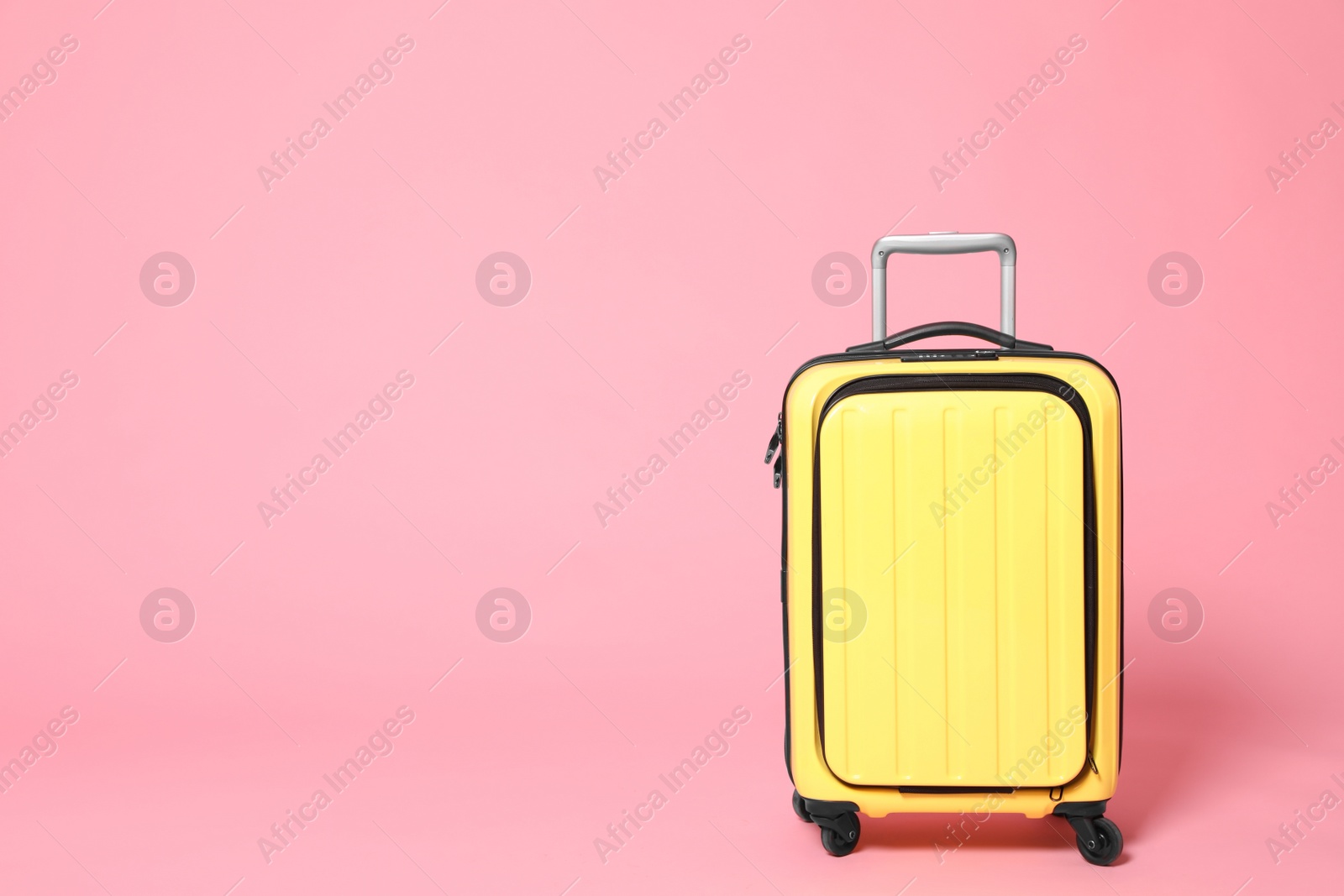 Photo of Stylish yellow suitcase on pink background. Space for text