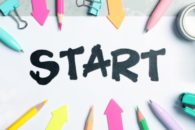 Sheet of paper with word Start and stationery on table, flat lay Photo of Sheet of paper with word Start and stationery on table, flat lay