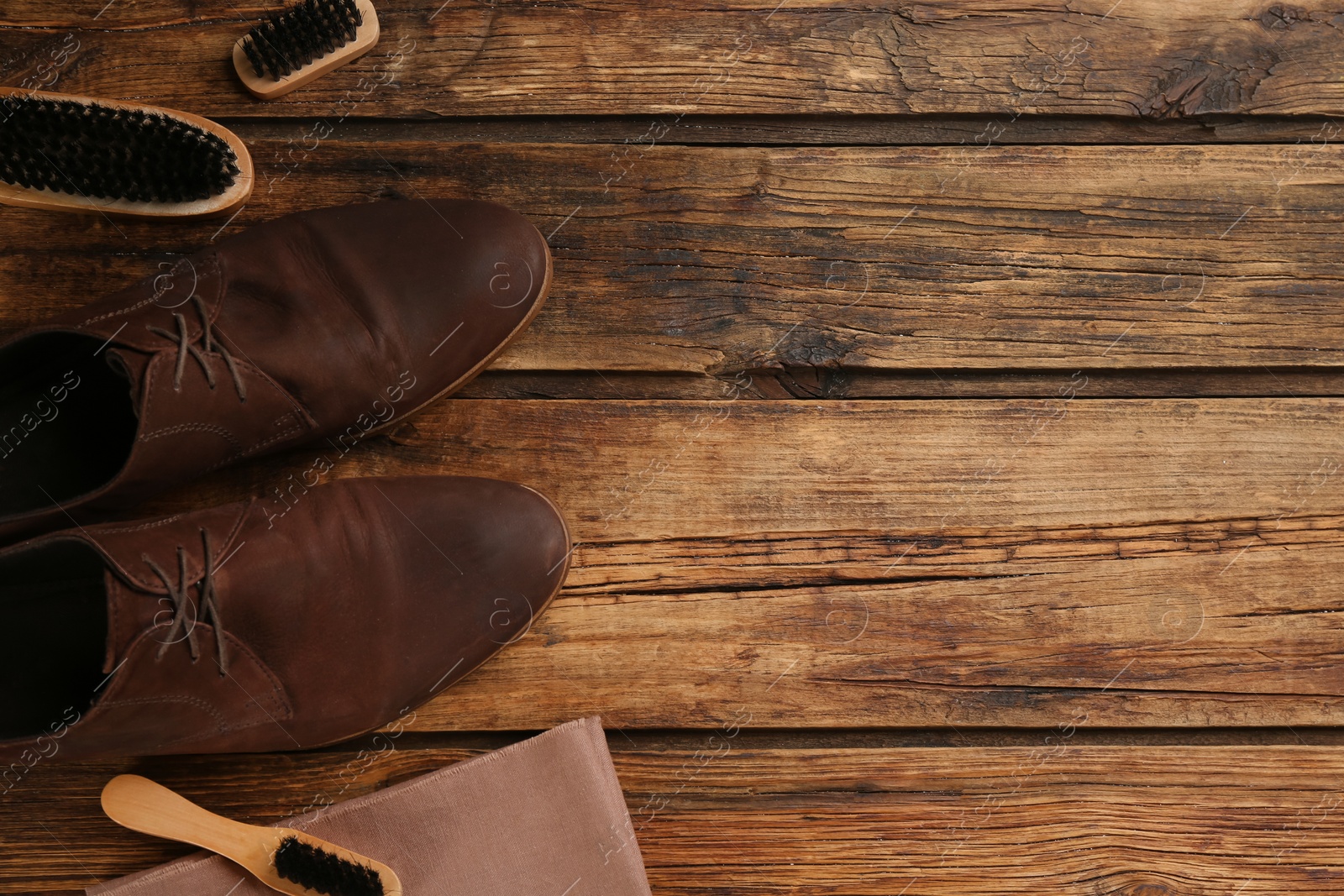 Stylish footwear with shoe care accessories on wooden table, flat lay. Space for text Photo of Stylish footwear with shoe care accessories on wooden table, flat lay. Space for text