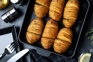 Delicious homemade Hasselback potatoes on black table, flat lay Photo of Delicious homemade Hasselback potatoes on black table, flat lay