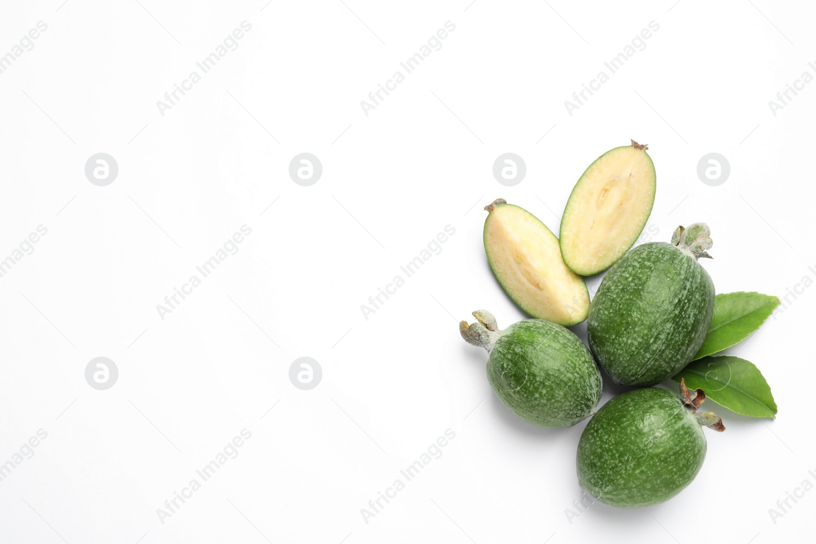 Cut and whole feijoas with leaves on white background, top view Photo of Cut and whole feijoas with leaves on white background, top view