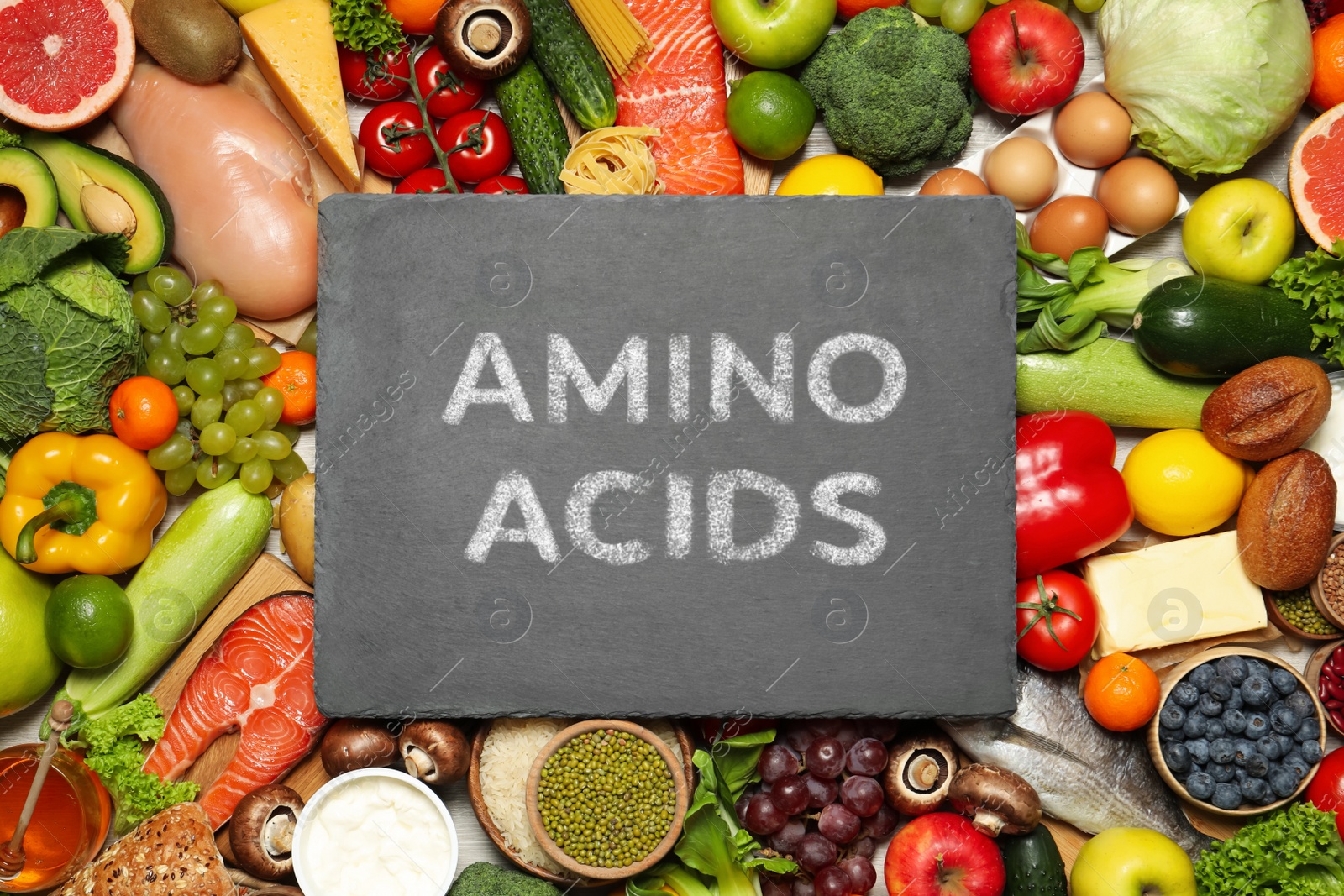 Different organic products and slate board with text AMINO ACIDS, top view Image of Different organic products and slate board with text AMINO ACIDS, top view