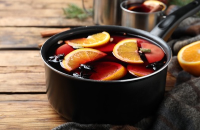 Delicious mulled wine on wooden table, closeup Photo of Delicious mulled wine on wooden table, closeup