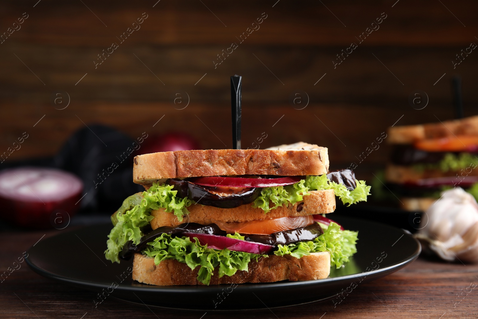 Delicious fresh eggplant sandwich served on wooden table Photo of Delicious fresh eggplant sandwich served on wooden table