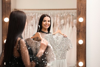 Woman choosing dress in rental clothing salon Photo of Woman choosing dress in rental clothing salon