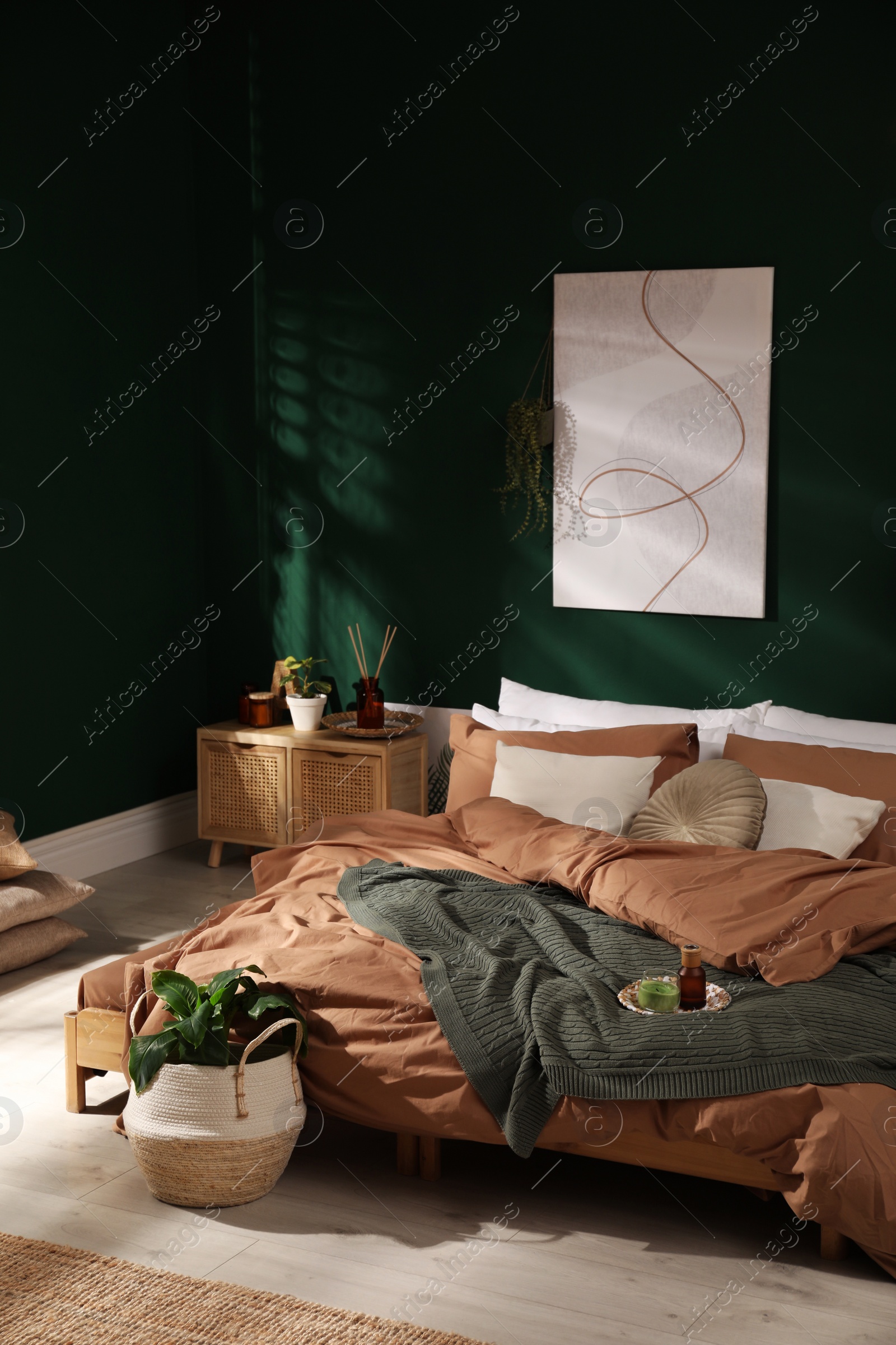 Stylish interior with large comfortable bed and potted plants Photo of Stylish interior with large comfortable bed and potted plants