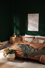 Stylish interior with large comfortable bed and potted plants Photo of Stylish interior with large comfortable bed and potted plants