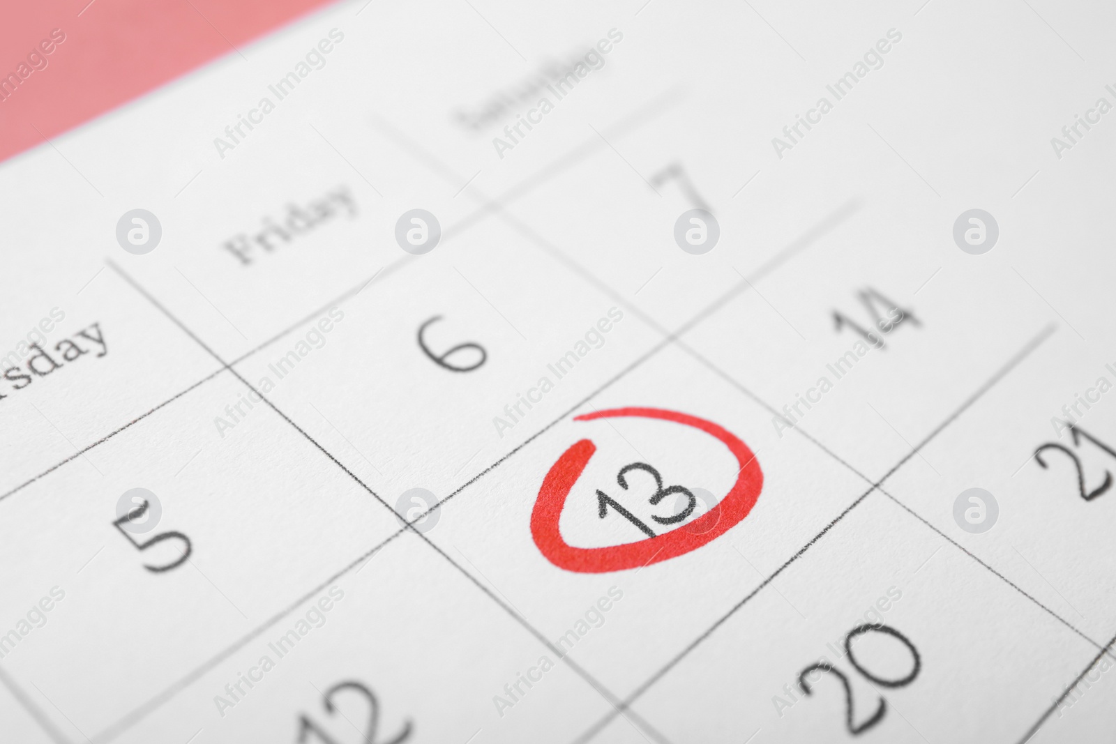 Photo of Calendar page with marked Friday 13, closeup. Bad luck superstition