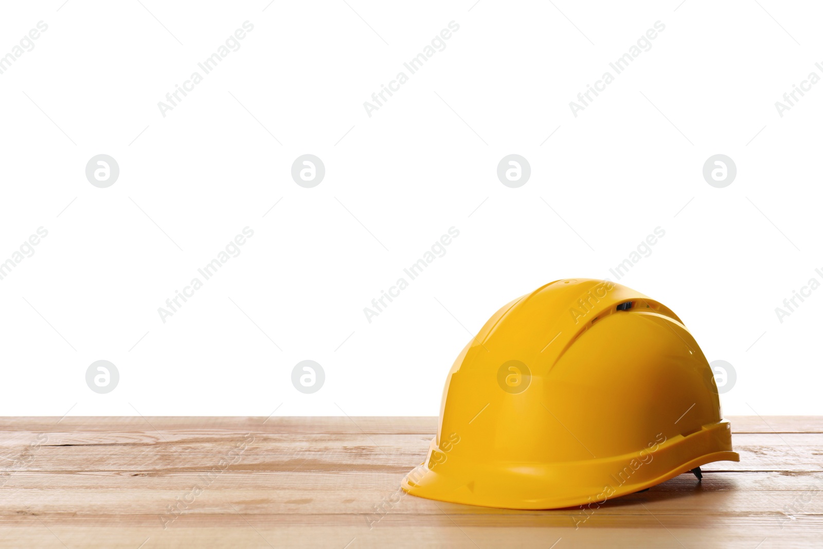 Yellow hard hat on wooden table against white background. Space for text Photo of Yellow hard hat on wooden table against white background. Space for text