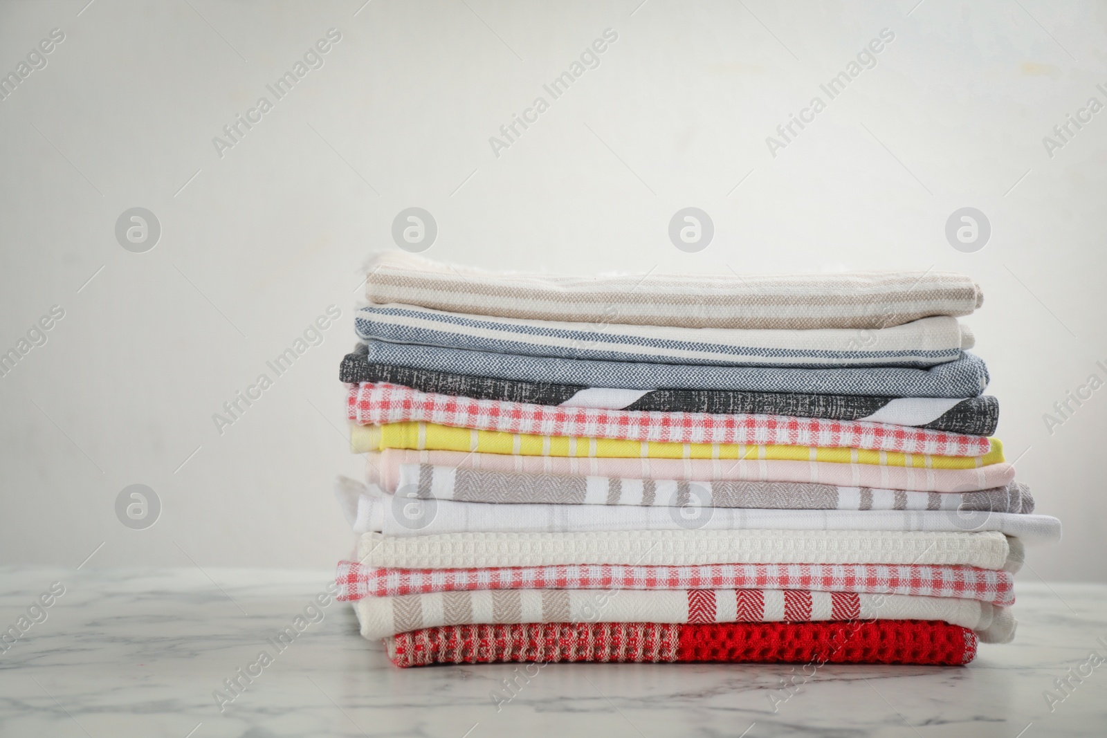 Stacked kitchen towels on white marble table Photo of Stacked kitchen towels on white marble table