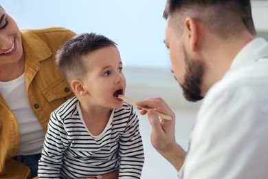Mother and son visiting pediatrician in hospital. Doctor examining little boy Photo of Mother and son visiting pediatrician in hospital. Doctor examining little boy