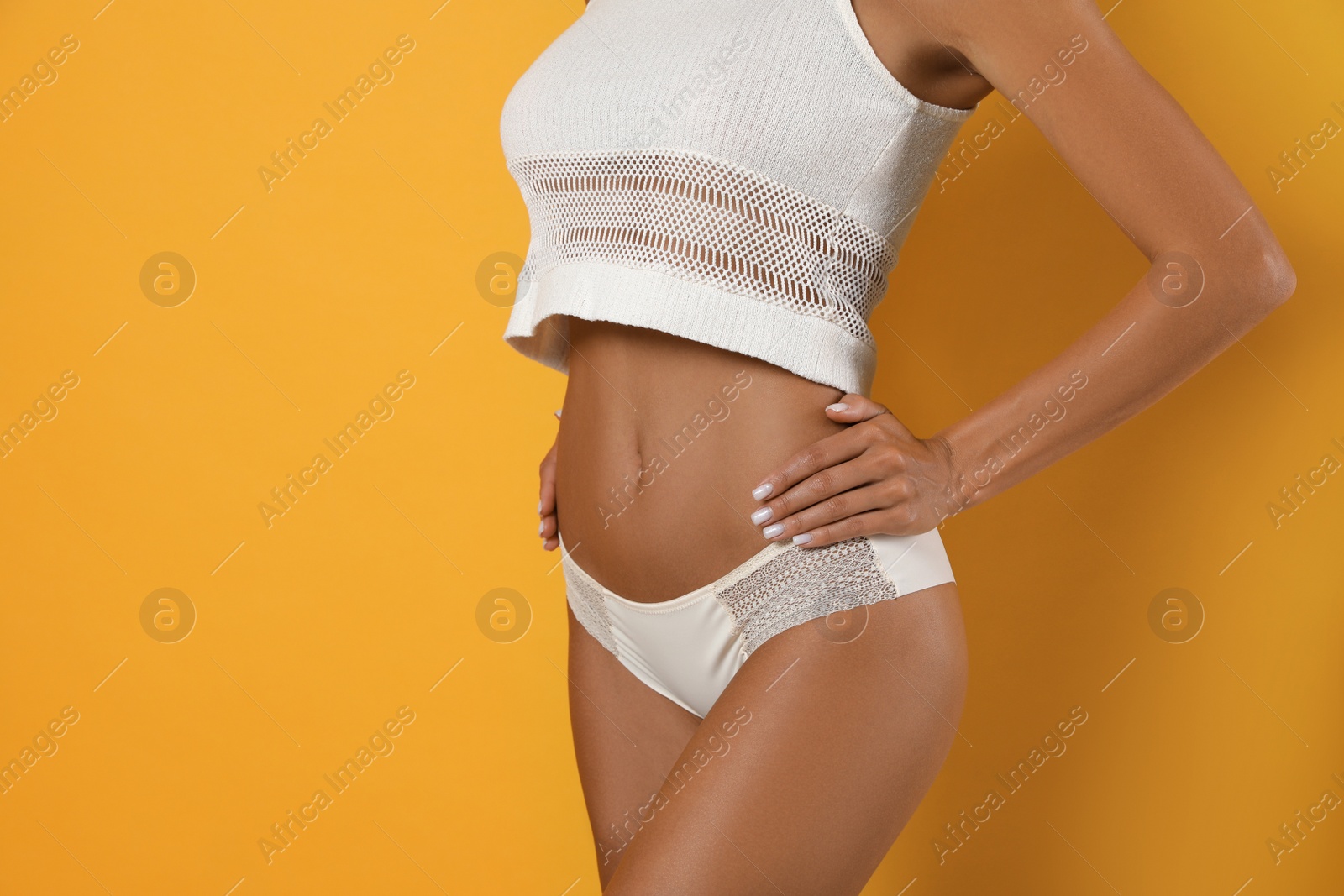 Woman in white sexy panties on yellow background, closeup Photo of Woman in white sexy panties on yellow background, closeup