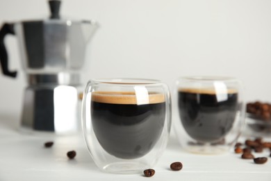 Tasty coffee and beans on white wooden table Photo of Tasty coffee and beans on white wooden table