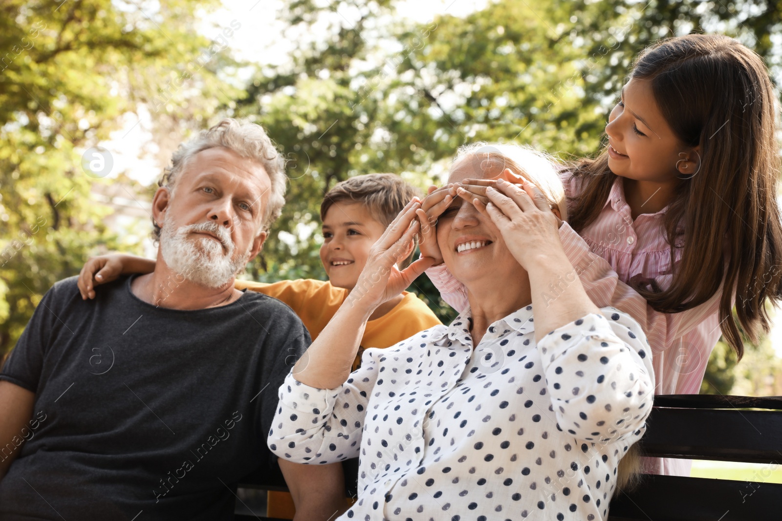 Happy grandparents with little children having fun together in park Photo of Happy grandparents with little children having fun together in park