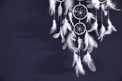 Beautiful dream catcher hanging on dark blue wall, closeup. Space for text Photo of Beautiful dream catcher hanging on dark blue wall, closeup. Space for text