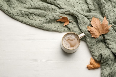 Flat lay composition with coffee and warm plaid on white wooden table, space for text Photo of Flat lay composition with coffee and warm plaid on white wooden table, space for text