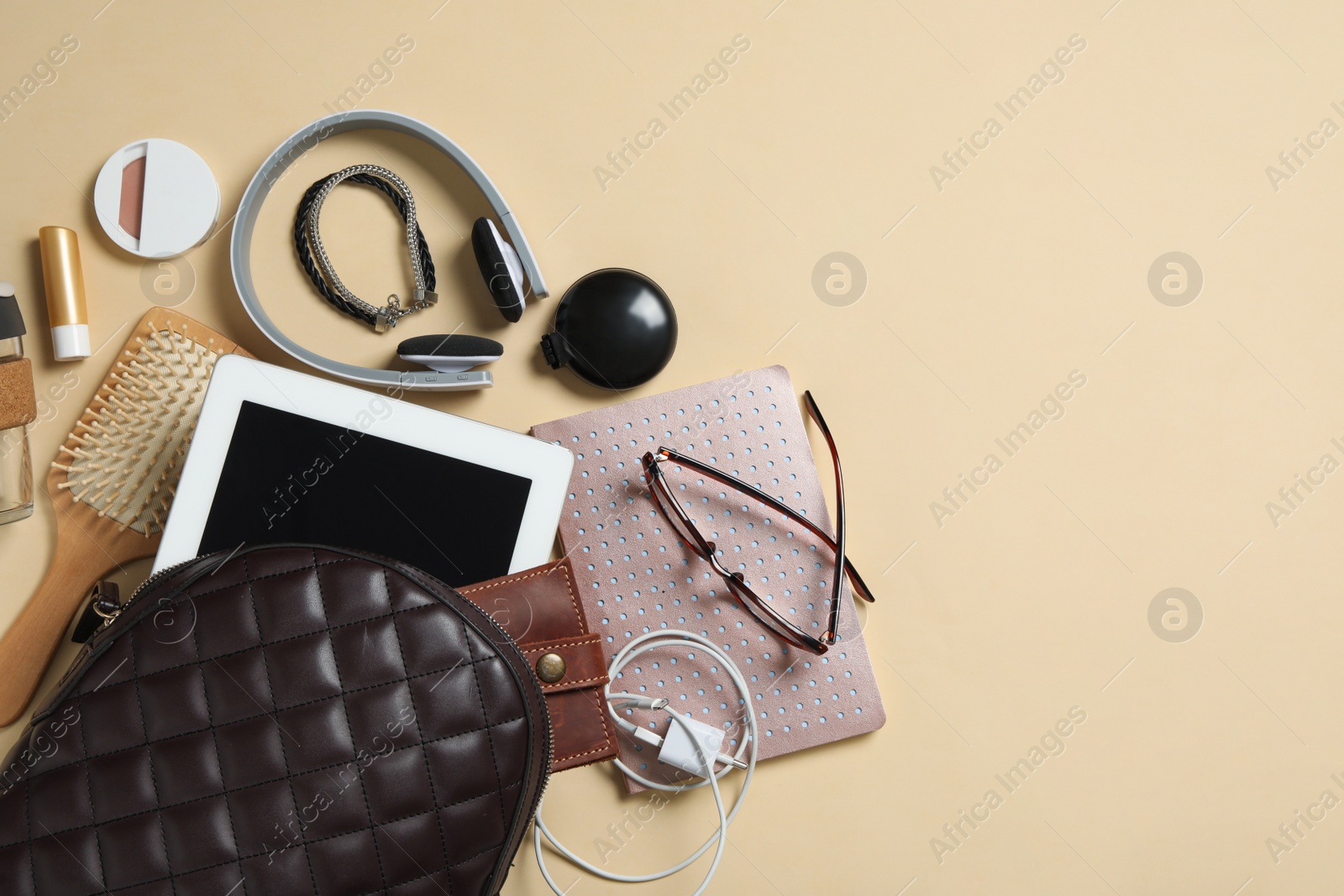 Stylish urban backpack with different items on beige background, flat lay. Space for text Photo of Stylish urban backpack with different items on beige background, flat lay. Space for text
