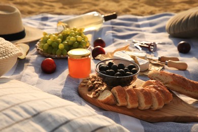 Different tasty snacks on picnic blanket outdoors Photo of Different tasty snacks on picnic blanket outdoors