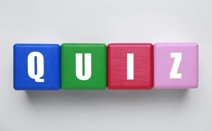 Colorful cubes with word Quiz on white background, top view Photo of Colorful cubes with word Quiz on white background, top view