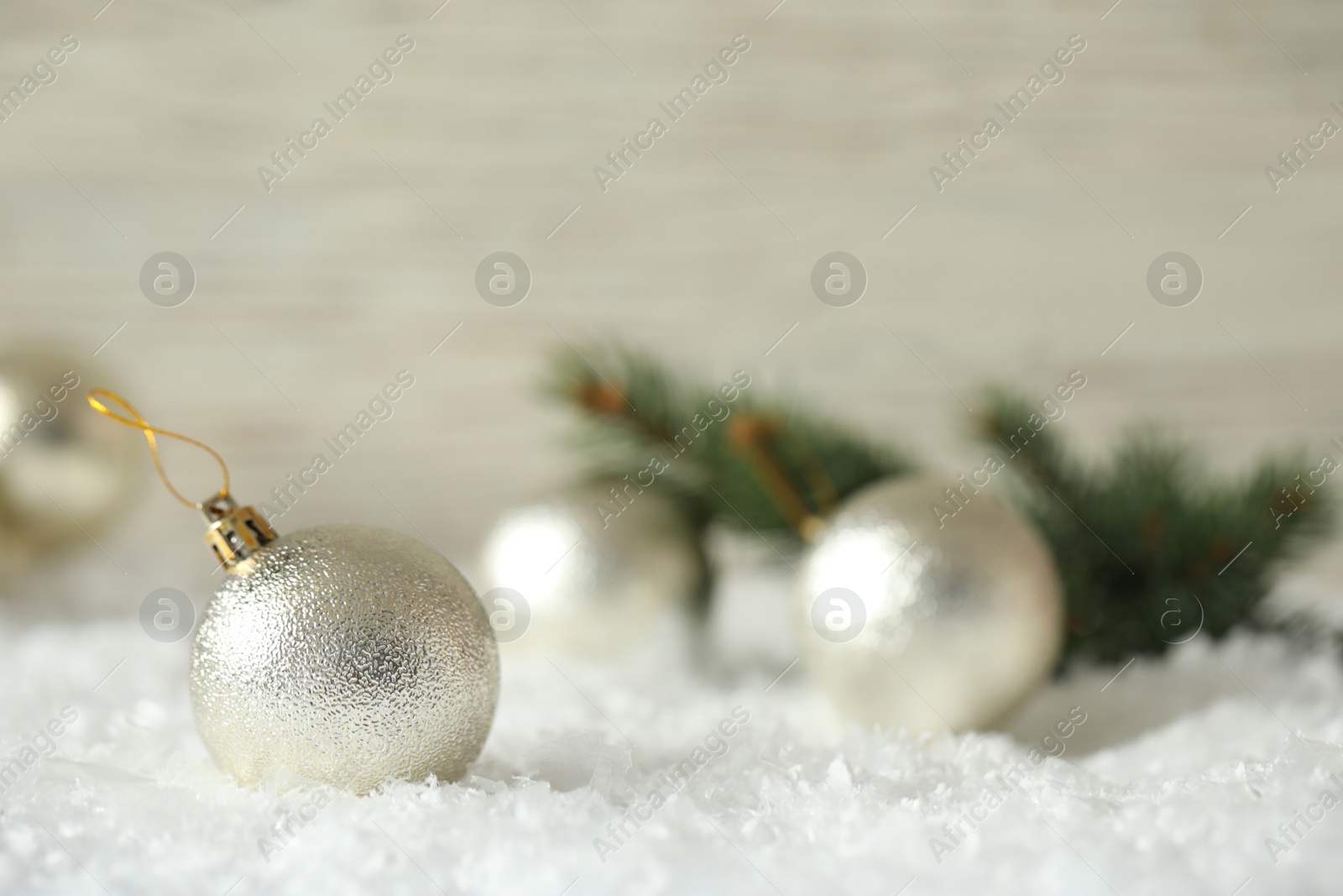 Beautiful Christmas ball on snow against blurred background. Space for text Photo of Beautiful Christmas ball on snow against blurred background. Space for text