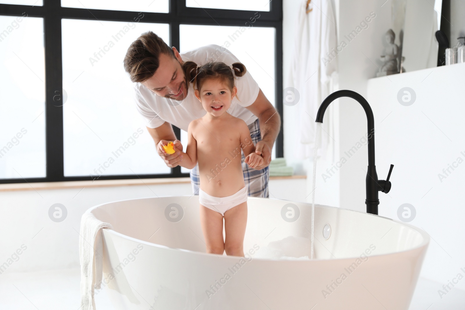 Young father with cute little daughter in bathroom Photo of Young father with cute little daughter in bathroom