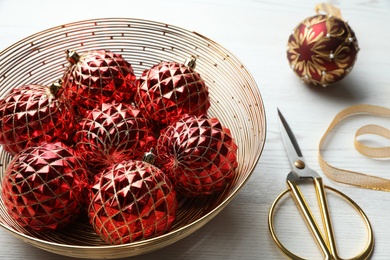 Composition with beautiful Christmas baubles on white wooden table Photo of Composition with beautiful Christmas baubles on white wooden table