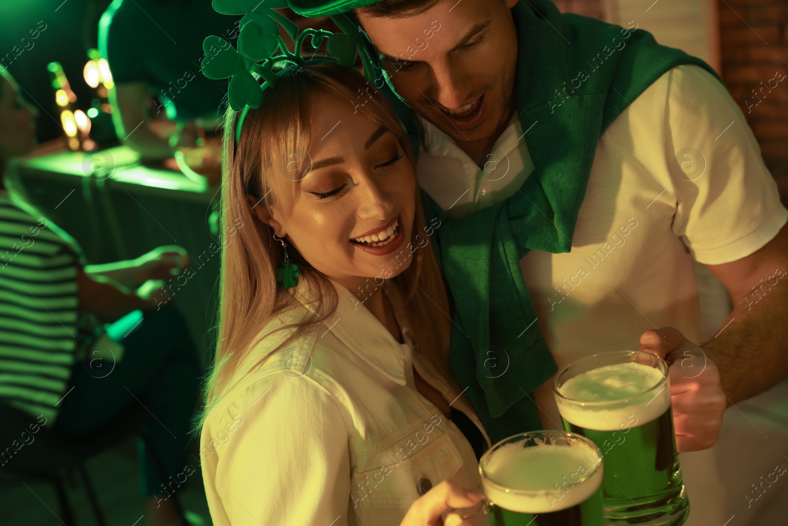 Couple with beer celebrating St Patrick's day in pub Photo of Couple with beer celebrating St Patrick's day in pub
