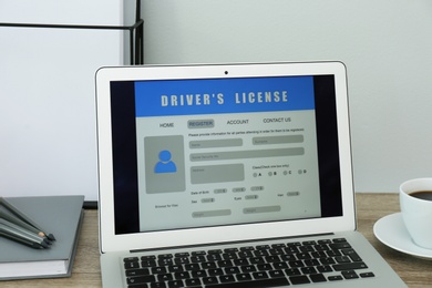 Laptop with driver's license application form on table in office Photo of Laptop with driver's license application form on table in office