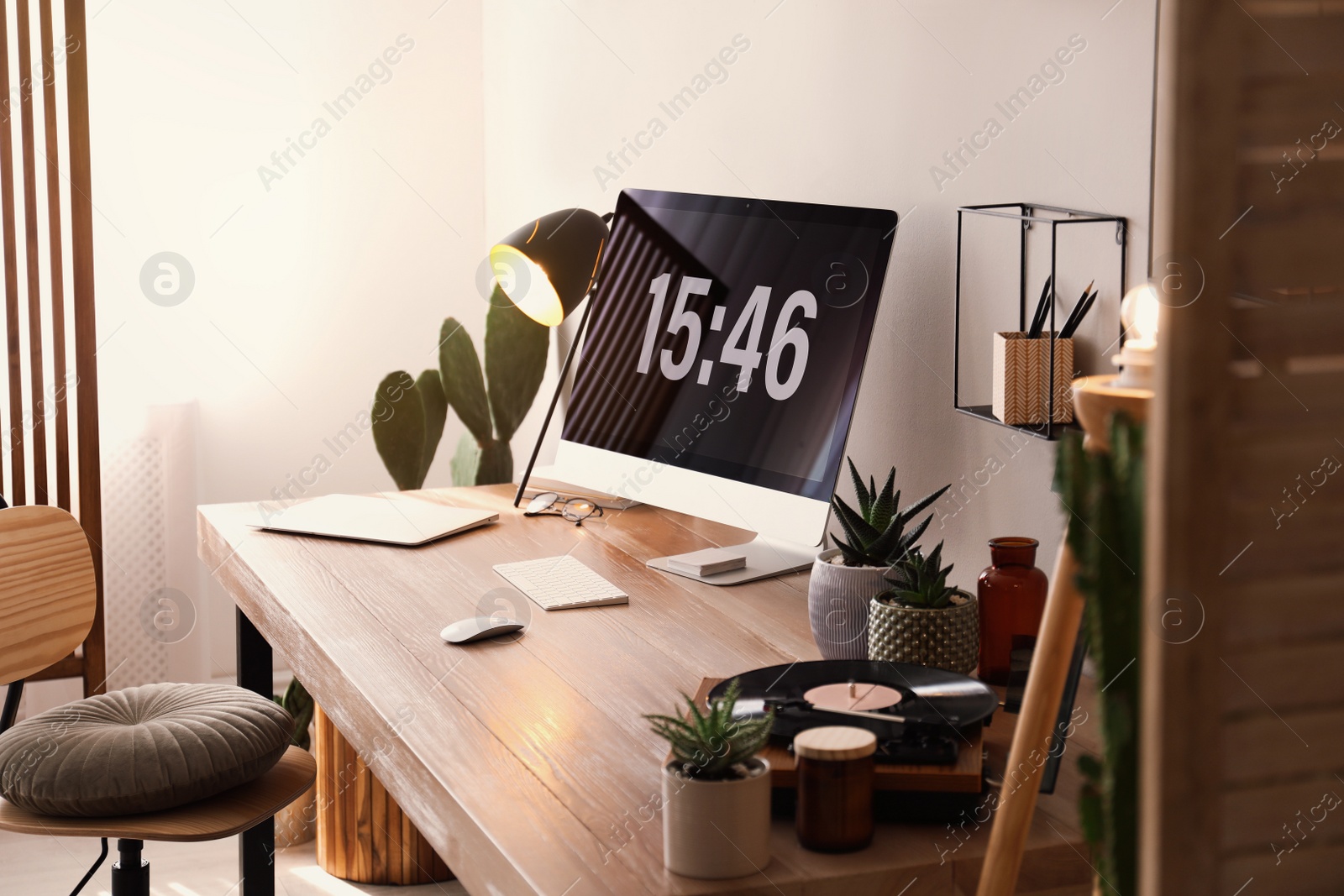Modern computer and laptop on wooden desk in room. Interior design Photo of Modern computer and laptop on wooden desk in room. Interior design