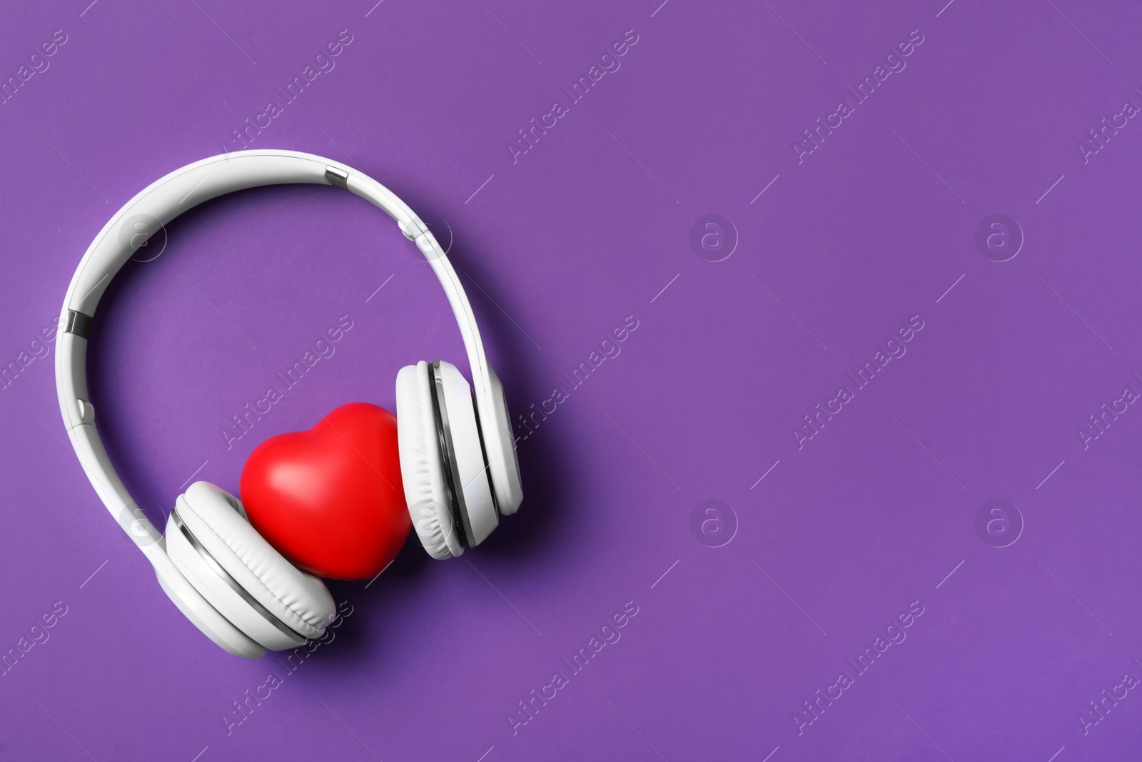 Modern headphones and red heart on purple background, flat lay with space for text. Listening love music songs Photo of Modern headphones and red heart on purple background, flat lay with space for text. Listening love music songs