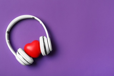 Modern headphones and red heart on purple background, flat lay with space for text. Listening love music songs Photo of Modern headphones and red heart on purple background, flat lay with space for text. Listening love music songs