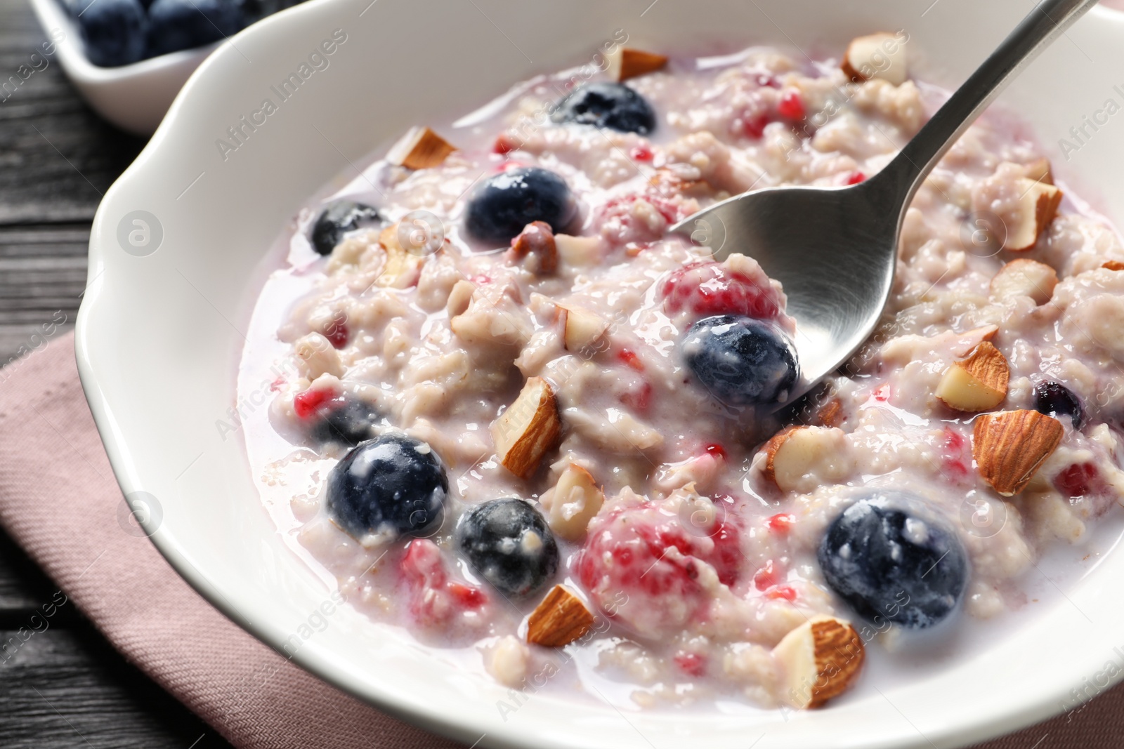 Tasty oatmeal porridge with toppings on wooden table, closeup Photo of Tasty oatmeal porridge with toppings on wooden table, closeup