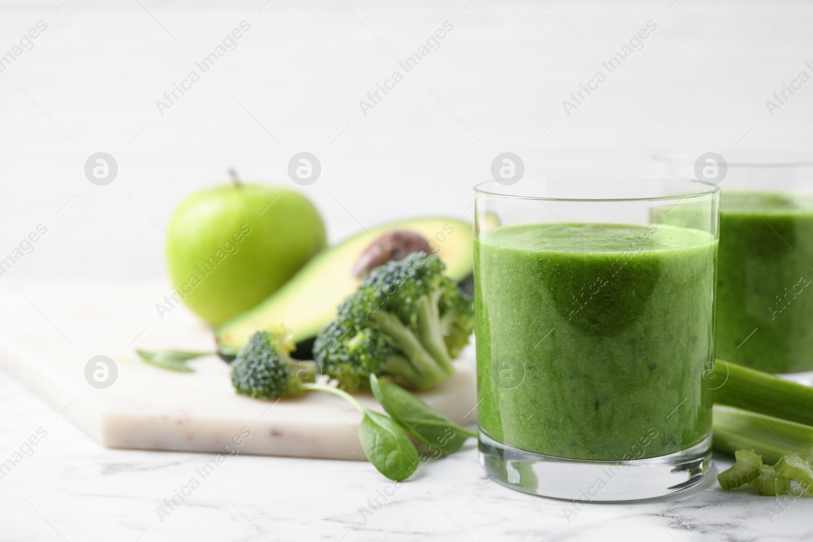 Delicious fresh green juice on white marble table. Space for text Photo of Delicious fresh green juice on white marble table. Space for text