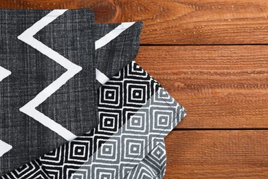 Beautiful kitchen towels on wooden table, flat lay. Space for text Photo of Beautiful kitchen towels on wooden table, flat lay. Space for text