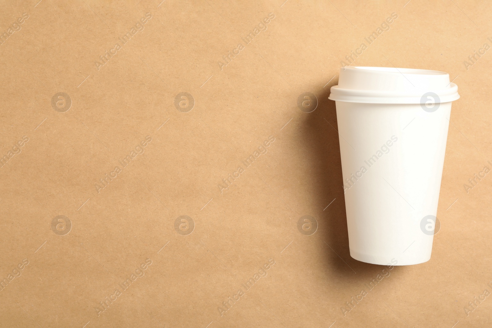 Takeaway paper coffee cup on beige background, top view. Space for text Photo of Takeaway paper coffee cup on beige background, top view. Space for text
