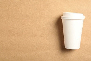 Takeaway paper coffee cup on beige background, top view. Space for text Photo of Takeaway paper coffee cup on beige background, top view. Space for text