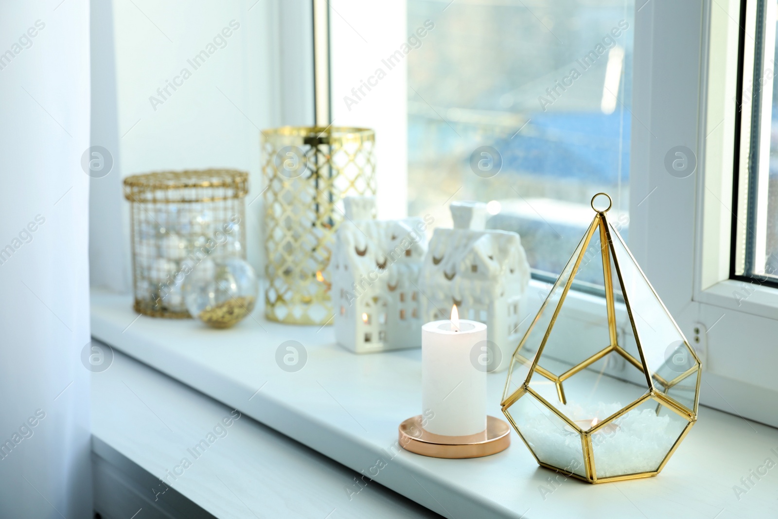 Photo of Beautiful lanterns with burning candles and Christmas decorations on window sill