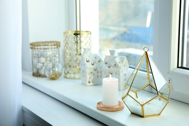 Beautiful lanterns with burning candles and Christmas decorations on window sill Photo of Beautiful lanterns with burning candles and Christmas decorations on window sill