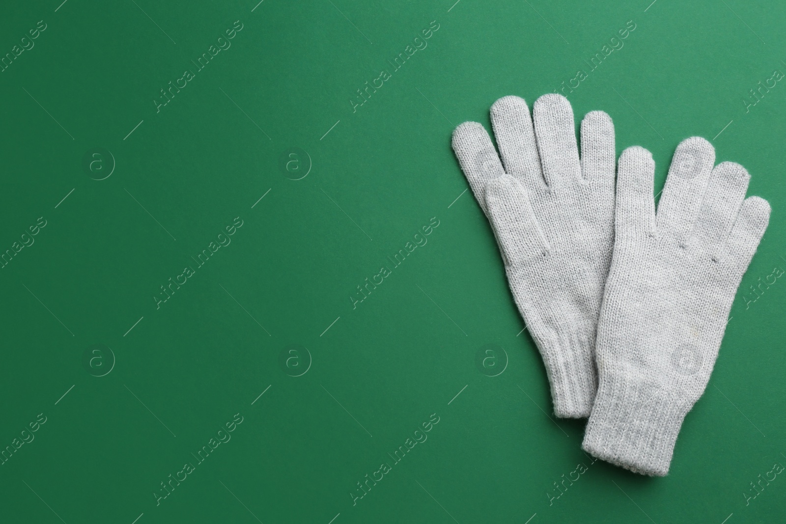 Pair of stylish woolen gloves on green background, flat lay. Space for text Photo of Pair of stylish woolen gloves on green background, flat lay. Space for text