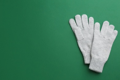 Pair of stylish woolen gloves on green background, flat lay. Space for text Photo of Pair of stylish woolen gloves on green background, flat lay. Space for text
