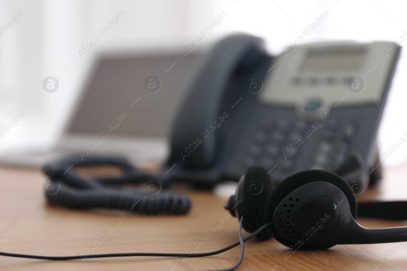 Headset on wooden table indoors, closeup with space for text. Hotline service Photo of Headset on wooden table indoors, closeup with space for text. Hotline service