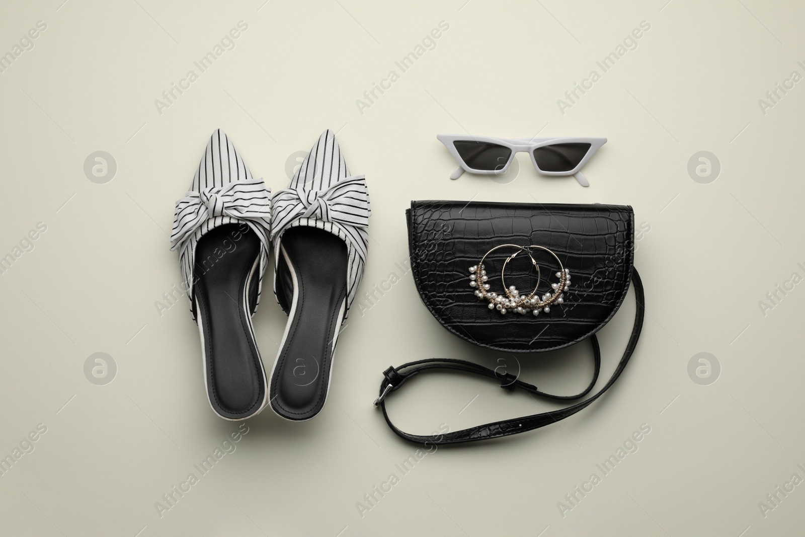 Stylish woman's bag, shoes, earrings and sunglasses on light background, flat lay Photo of Stylish woman's bag, shoes, earrings and sunglasses on light background, flat lay