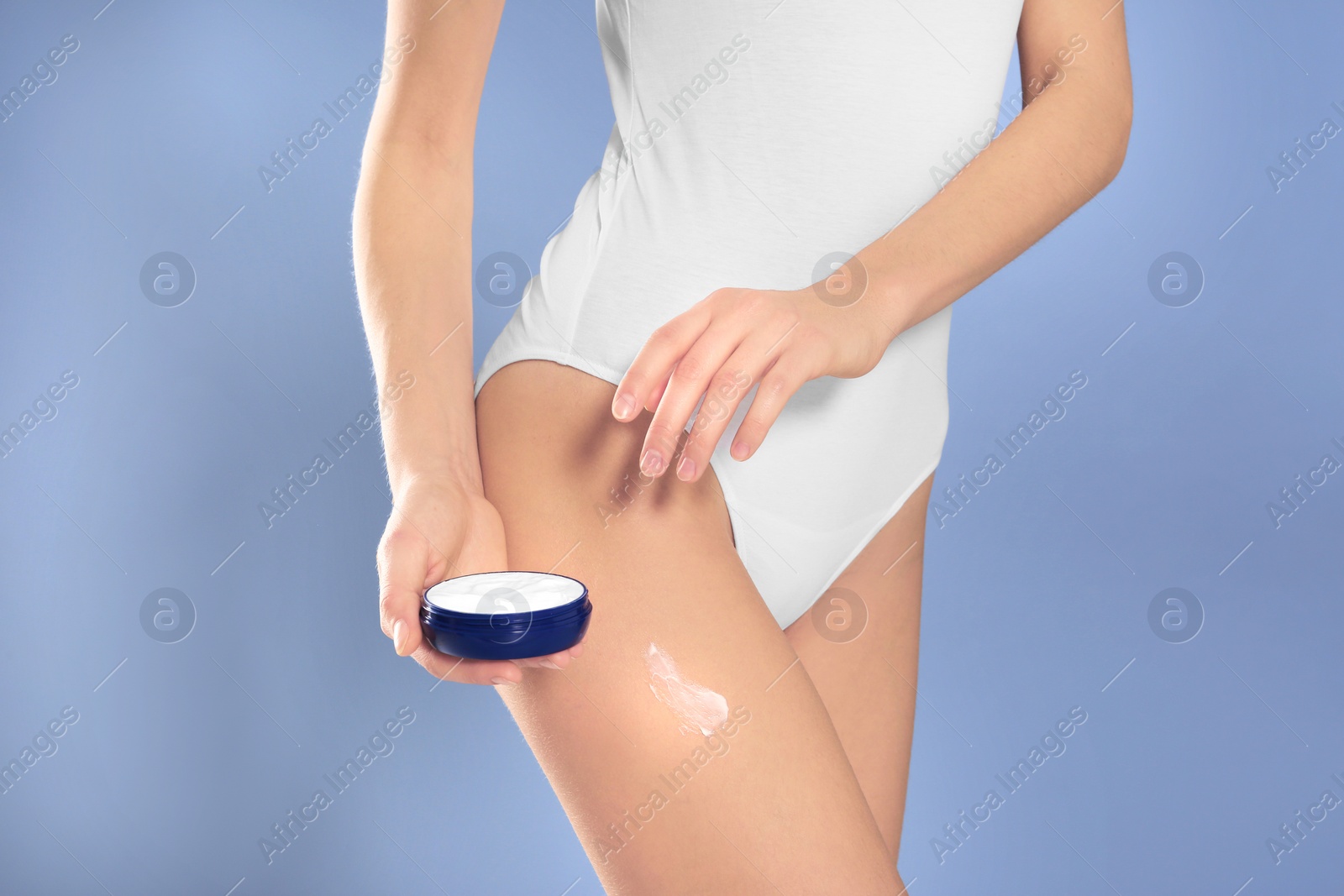 Photo of Young woman with jar of body cream on color background