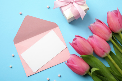 Flat lay composition with tulips and card on light blue background, space for text. Happy Mother's day Photo of Flat lay composition with tulips and card on light blue background, space for text. Happy Mother's day