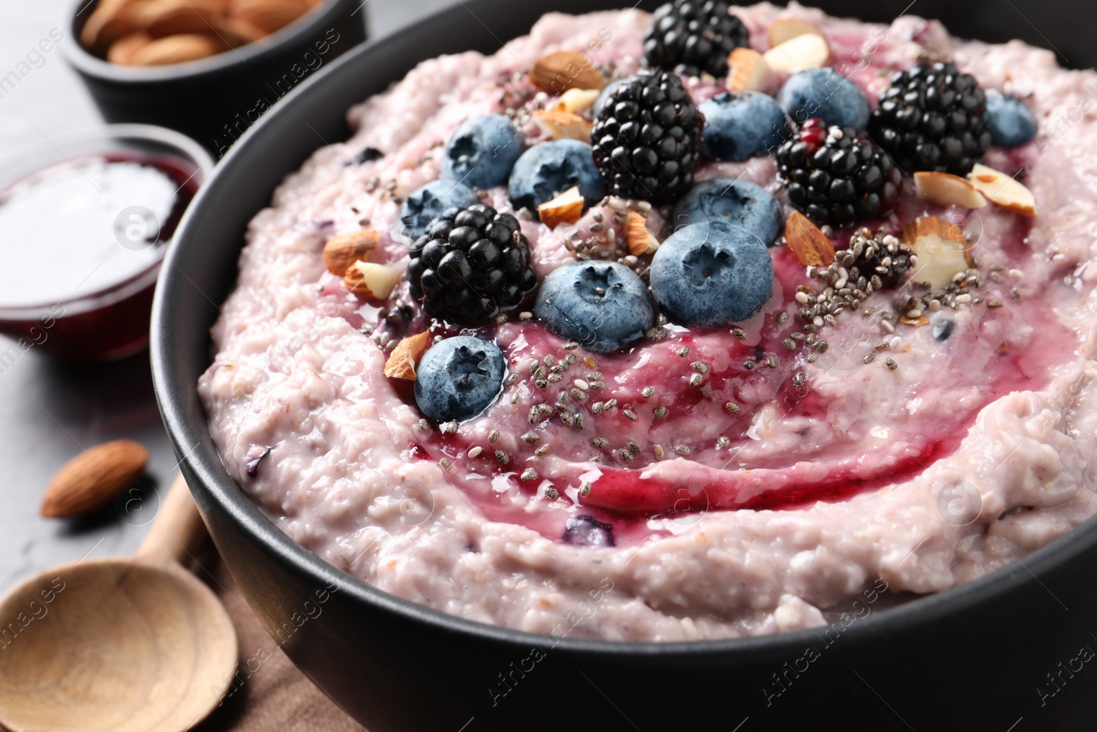 Tasty oatmeal porridge with toppings in bowl on table, closeup Photo of Tasty oatmeal porridge with toppings in bowl on table, closeup