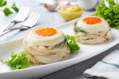 Delicious chicken aspic with eggs and vegetables on plate, closeup Photo of Delicious chicken aspic with eggs and vegetables on plate, closeup