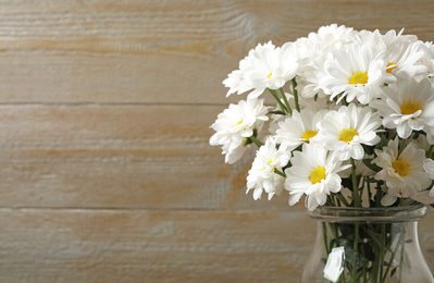 Beautiful white chrysanthemum flowers in glass vase on background. Space for text Photo of Beautiful white chrysanthemum flowers in glass vase on background. Space for text