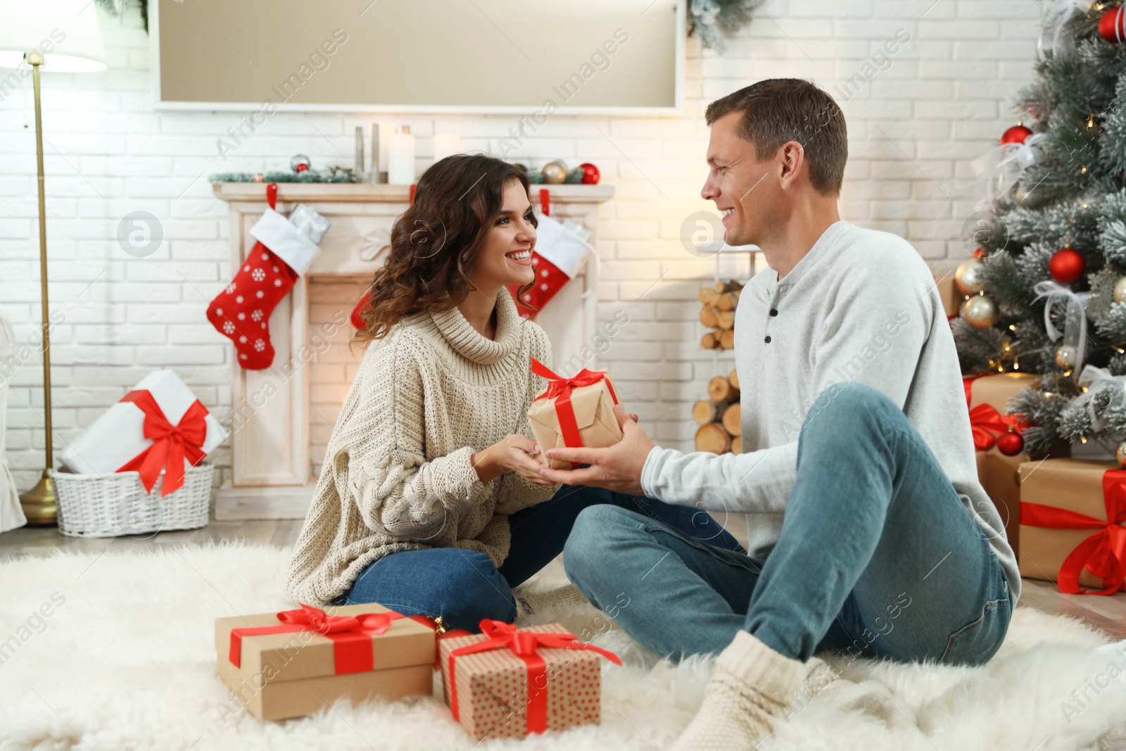 Happy couple with Christmas gift at home Image of Happy couple with Christmas gift at home