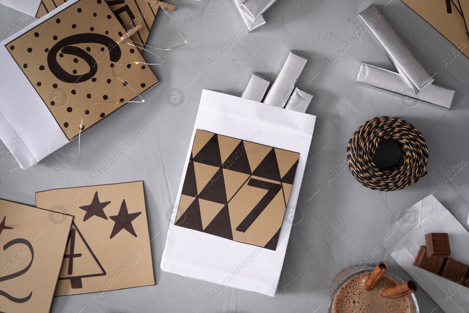 Flat lay composition with gift bags and chocolate on grey table. Creating advent calendar Photo of Flat lay composition with gift bags and chocolate on grey table. Creating advent calendar